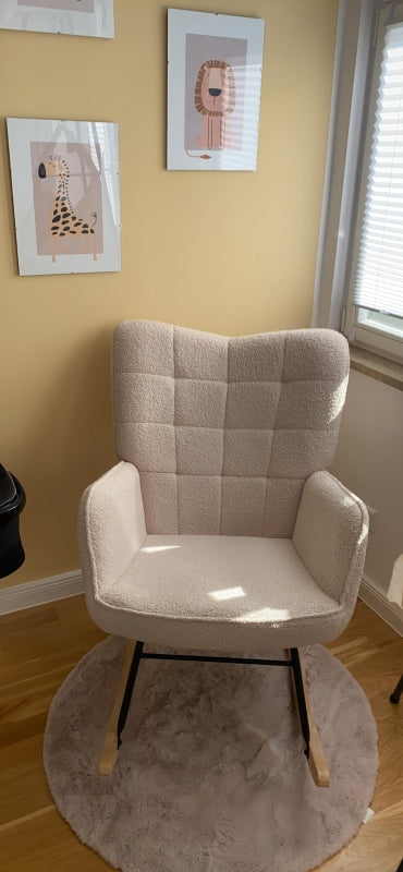 Beige armchair in a room with framed pictures on the wall.
